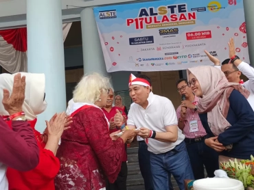 Ketua Umum Alste Indonesia Kukrit Suryo Wicaksono menyerahkan tumpeng kepada Endang, alumni Alste angkatan 1962, sebagai simbol penghormatan kepada alumni senior saat peluncuran Alste Emas di halaman SMAN 3 Semarang, Sabtu (15/8/2026). (suaramerdeka.com/Slamet Daryono)